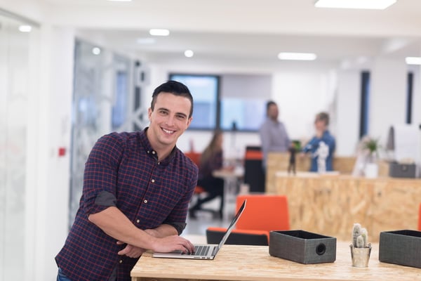 portrait of young businessman in casual clothes at modern startup business office space, working on laptop computer