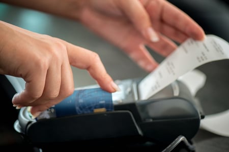 Hand taking receipt from pos terminal