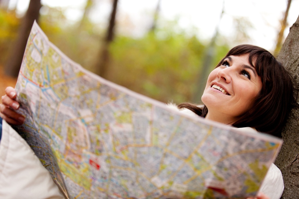 Lost female explorer holding a map outdoors