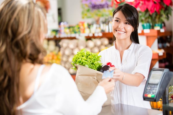 Shopping woman at the checkout paying by card