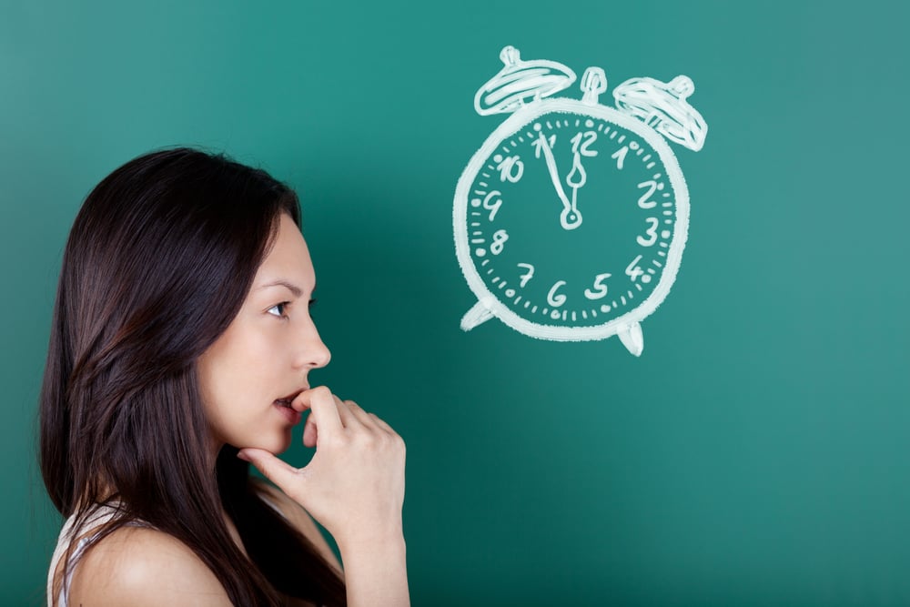 female student looking at a drawn clock showing five to twelve